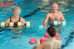 Healthy and fit senior couple enjoying their retirement in aqua aerobics training.